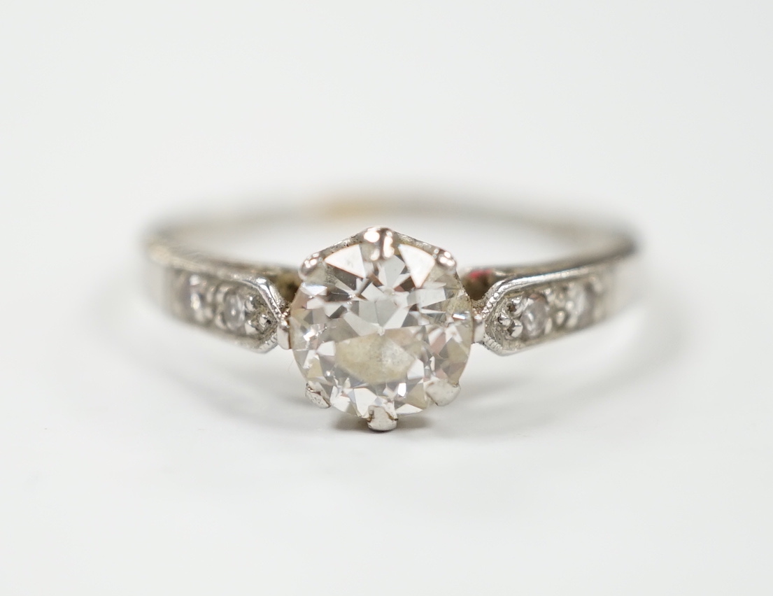 A white metal (stamped plat) and single stone diamond ring with diamond set shoulders, size M/N, gross weight 2.6 grams.